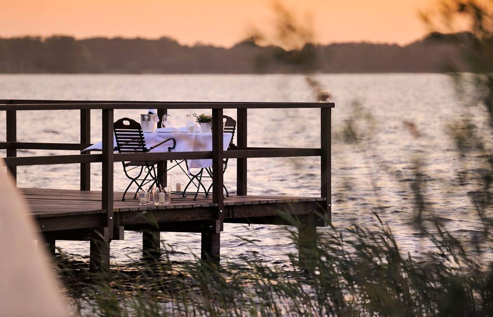 Romantischer Esstisch auf der Hotelterrasse am See